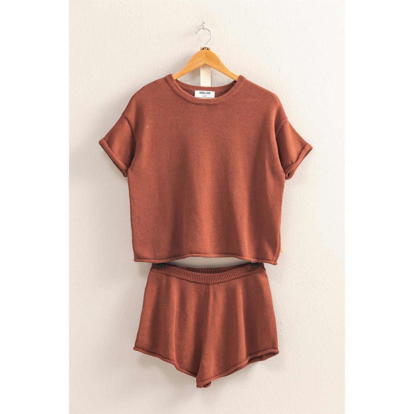 Brown outfit with top and shorts on a hanger against a white background