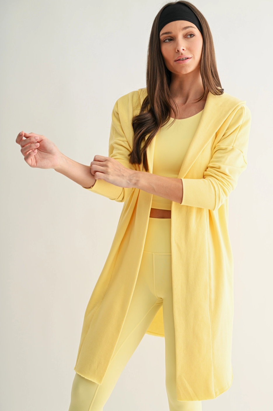 Woman wearing a yellow outfit on a plain background