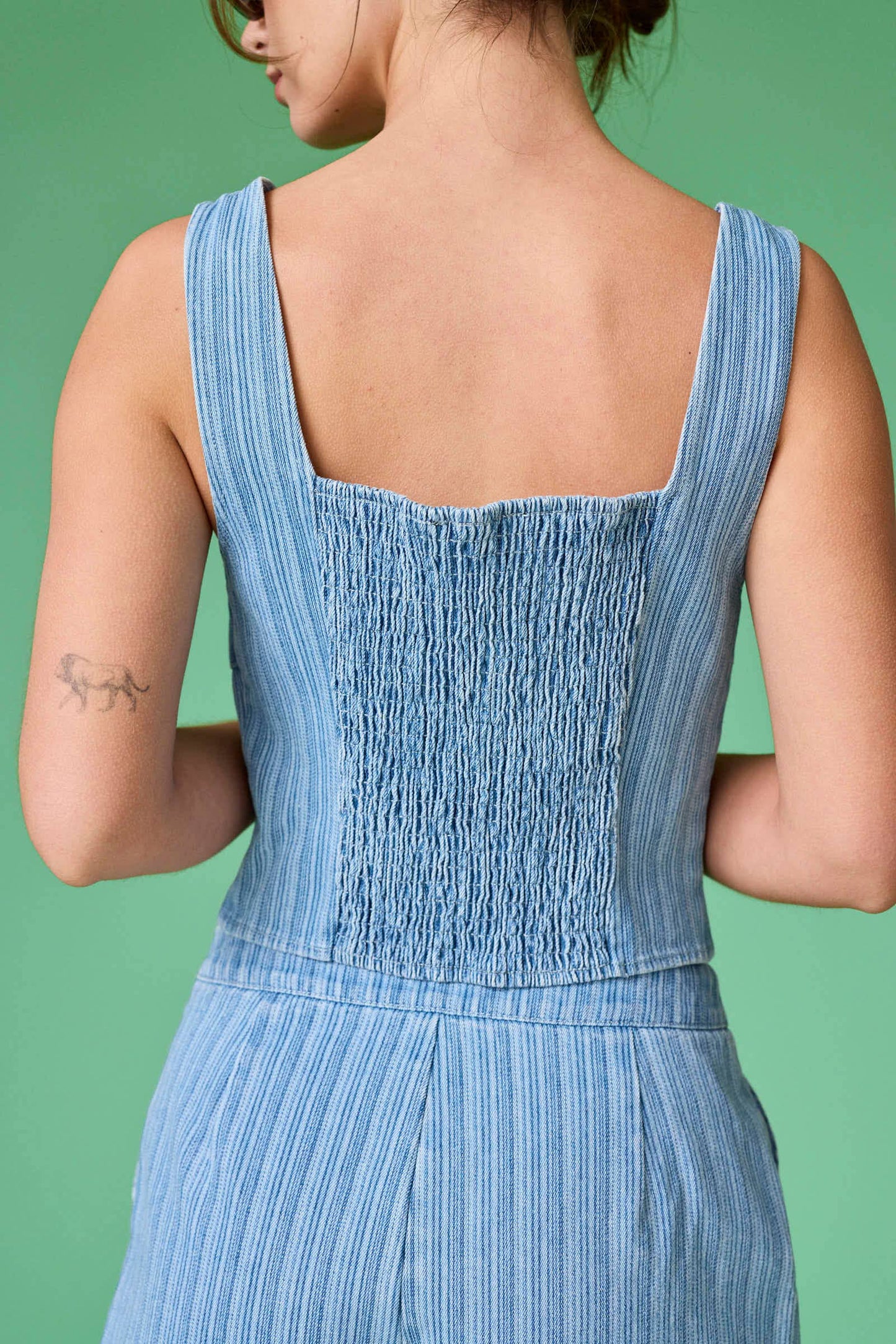 Blue striped dress worn by a person on a green background