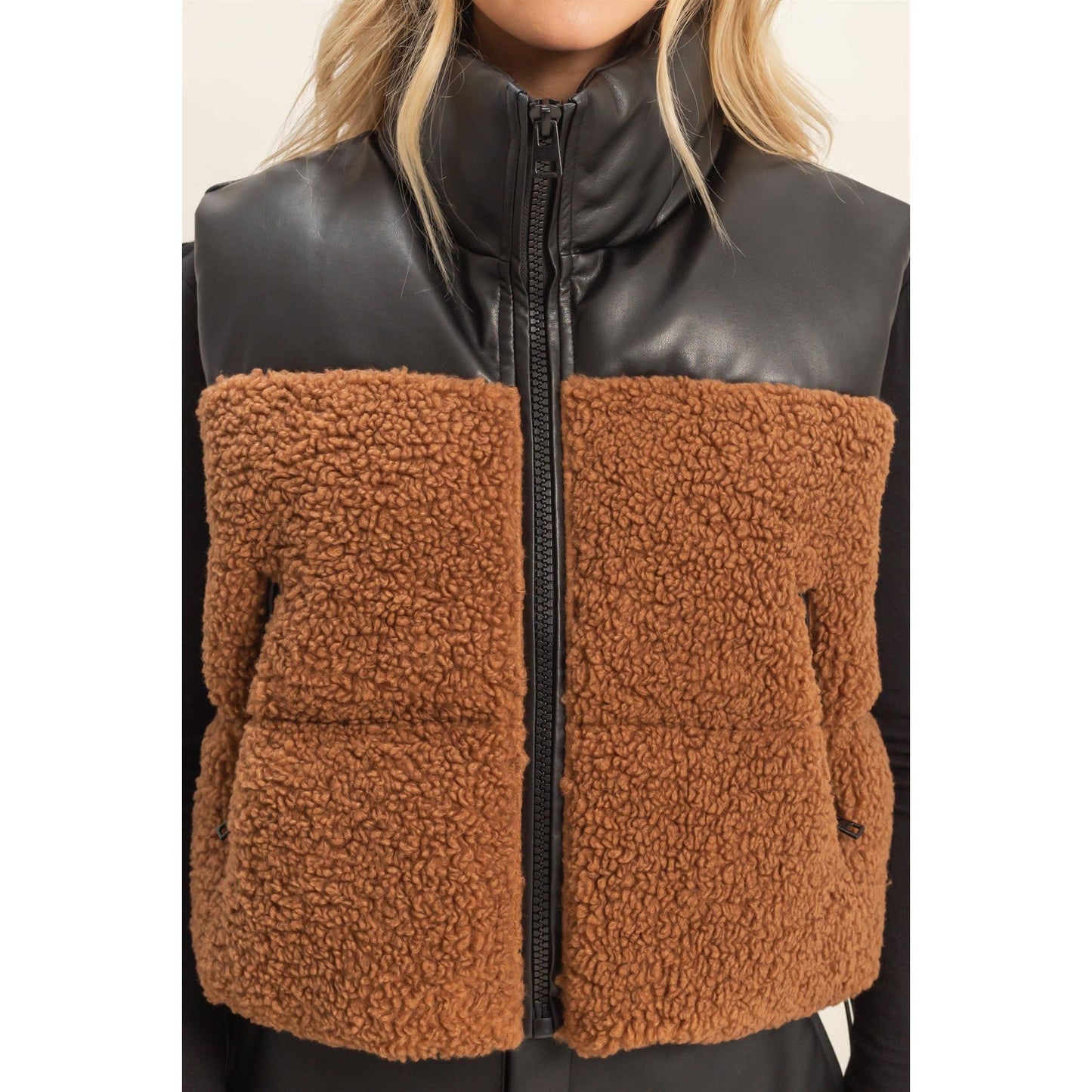 Black leather and brown fleece vest worn by a person