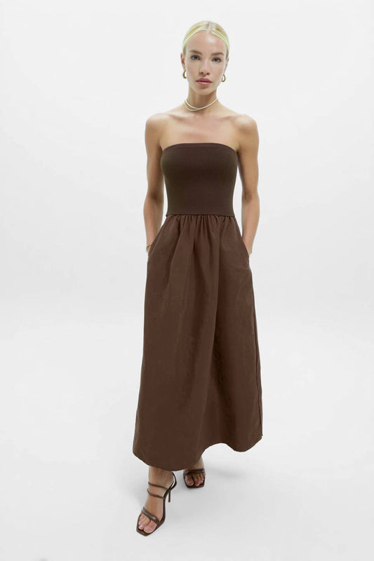 Woman wearing a brown strapless dress on a white background