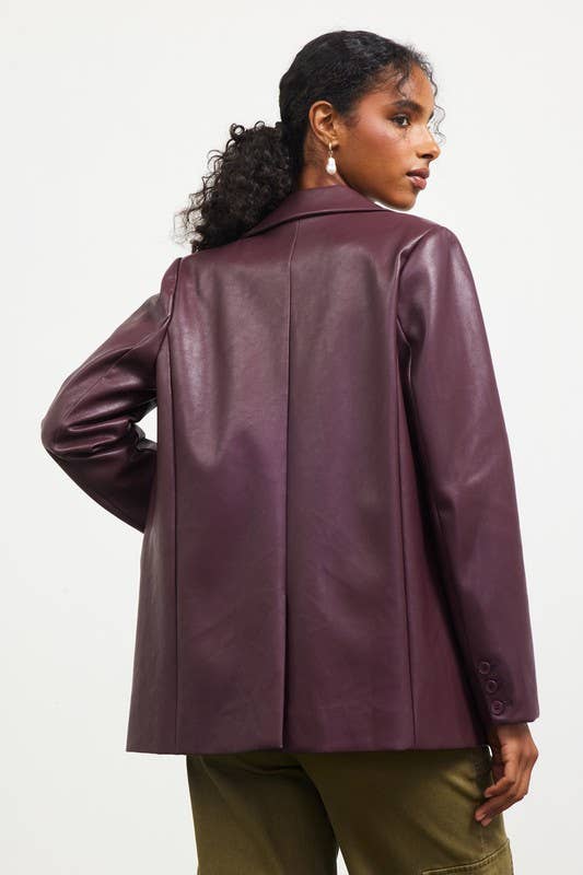 Woman wearing a purple leather jacket on a white background