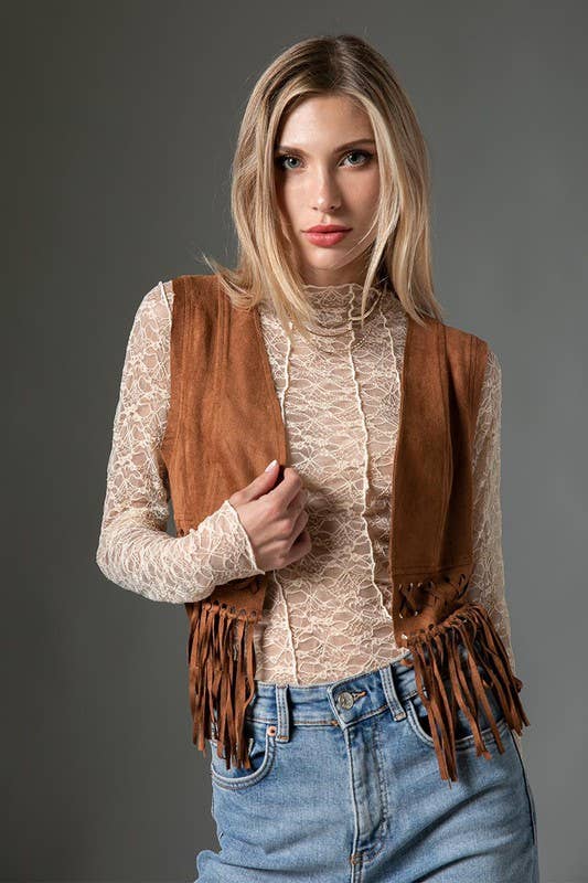 woman wearing a cream lace top with brown vest