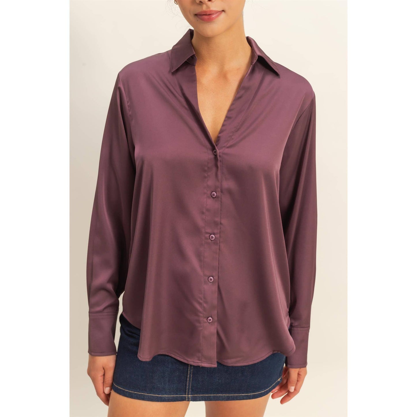 Woman wearing a purple button-up shirt with a plain background