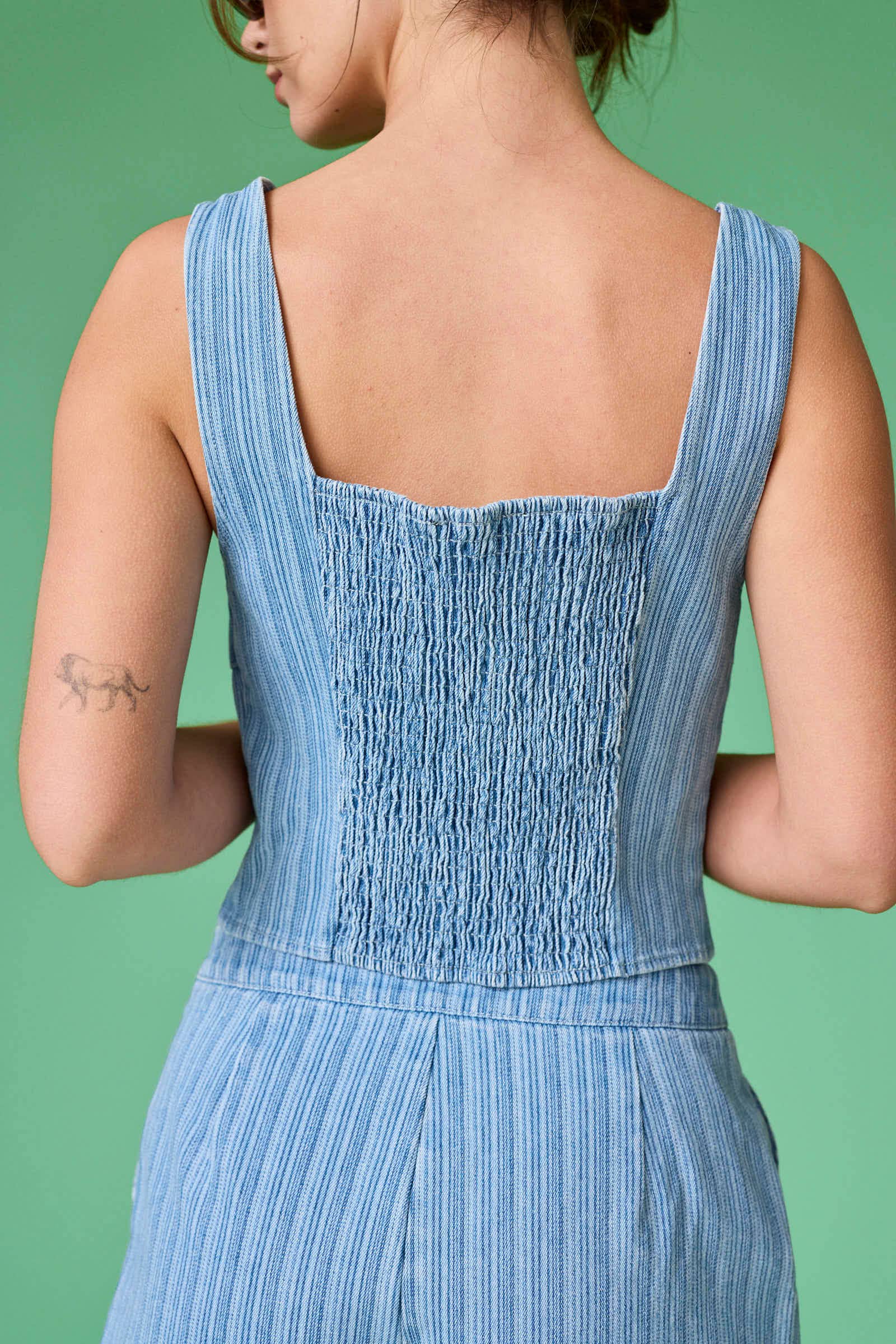 Blue striped dress worn by a person on a green background