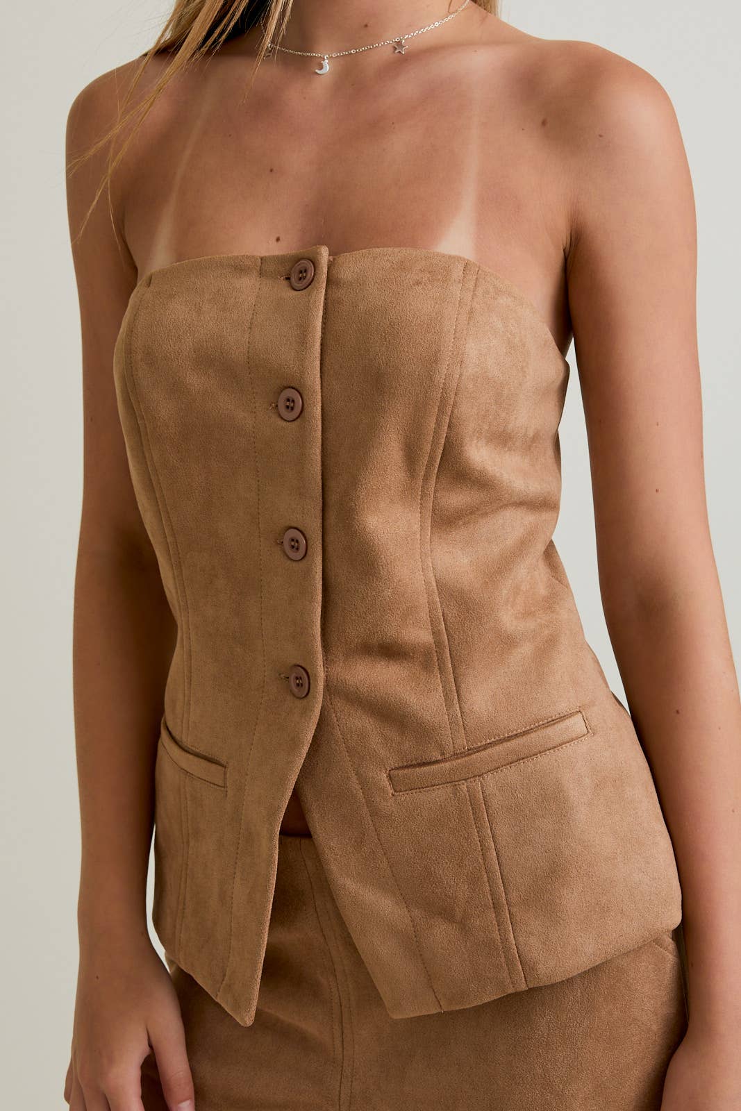 Brown suede strapless blazer worn by a person on a plain background