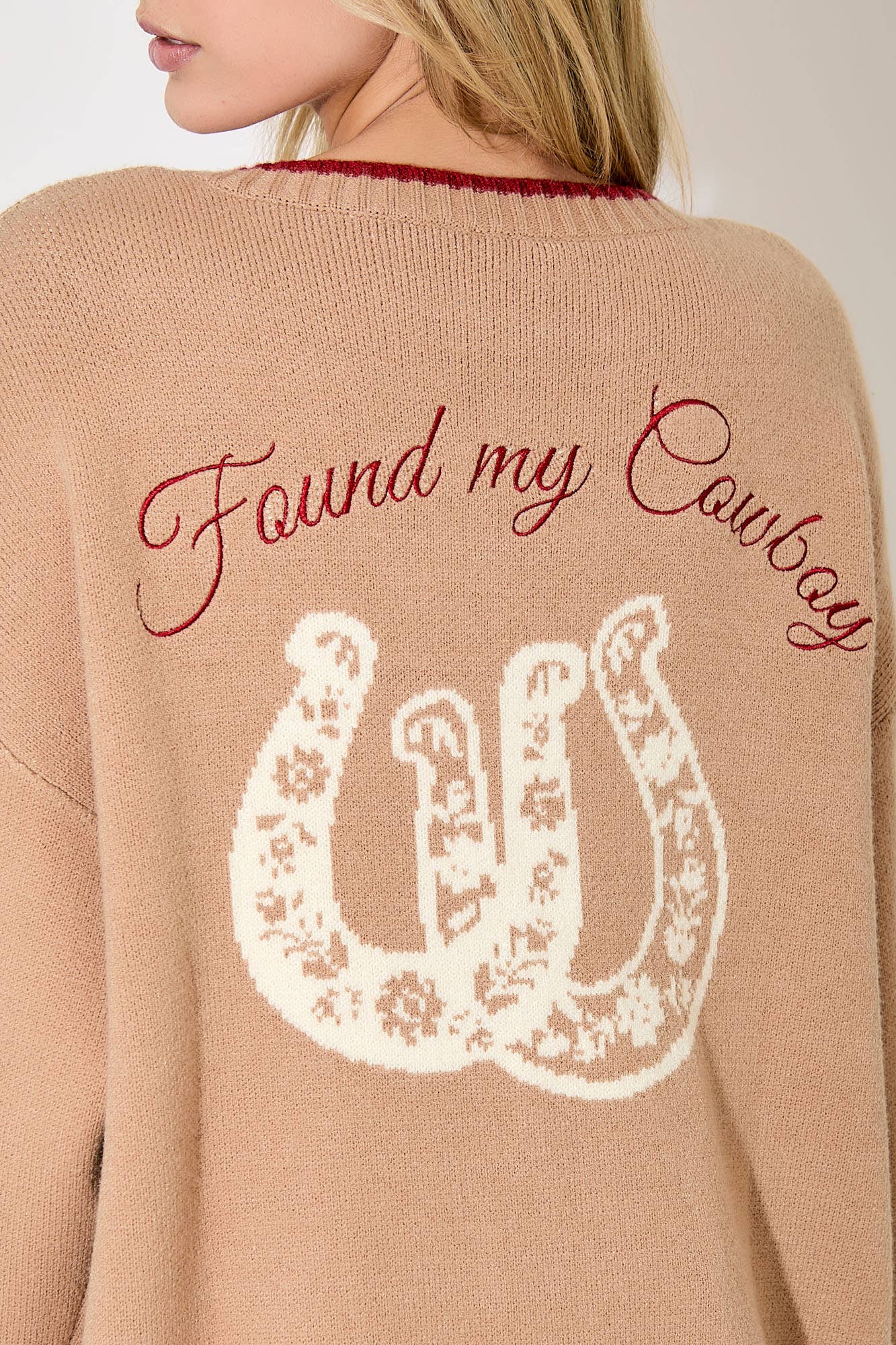 Beige sweater with 'Found my Cowboy' text and horseshoe design on the back.