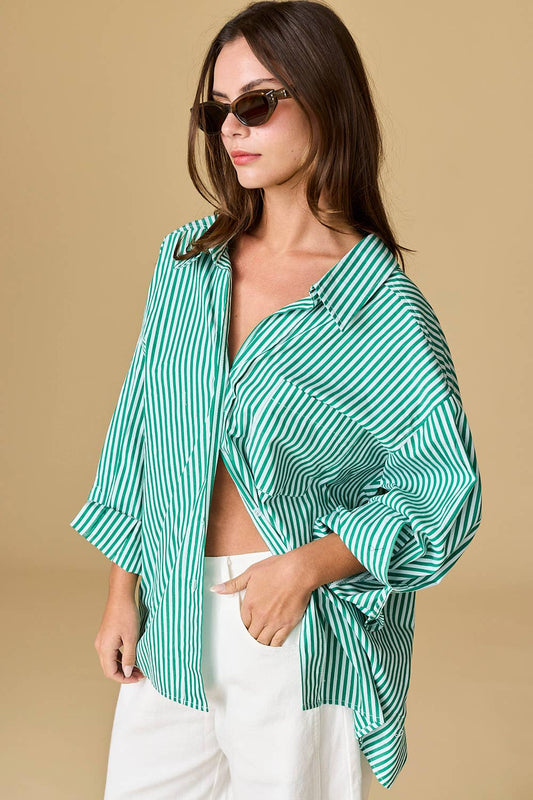 Woman wearing a green and white striped shirt with a beige background