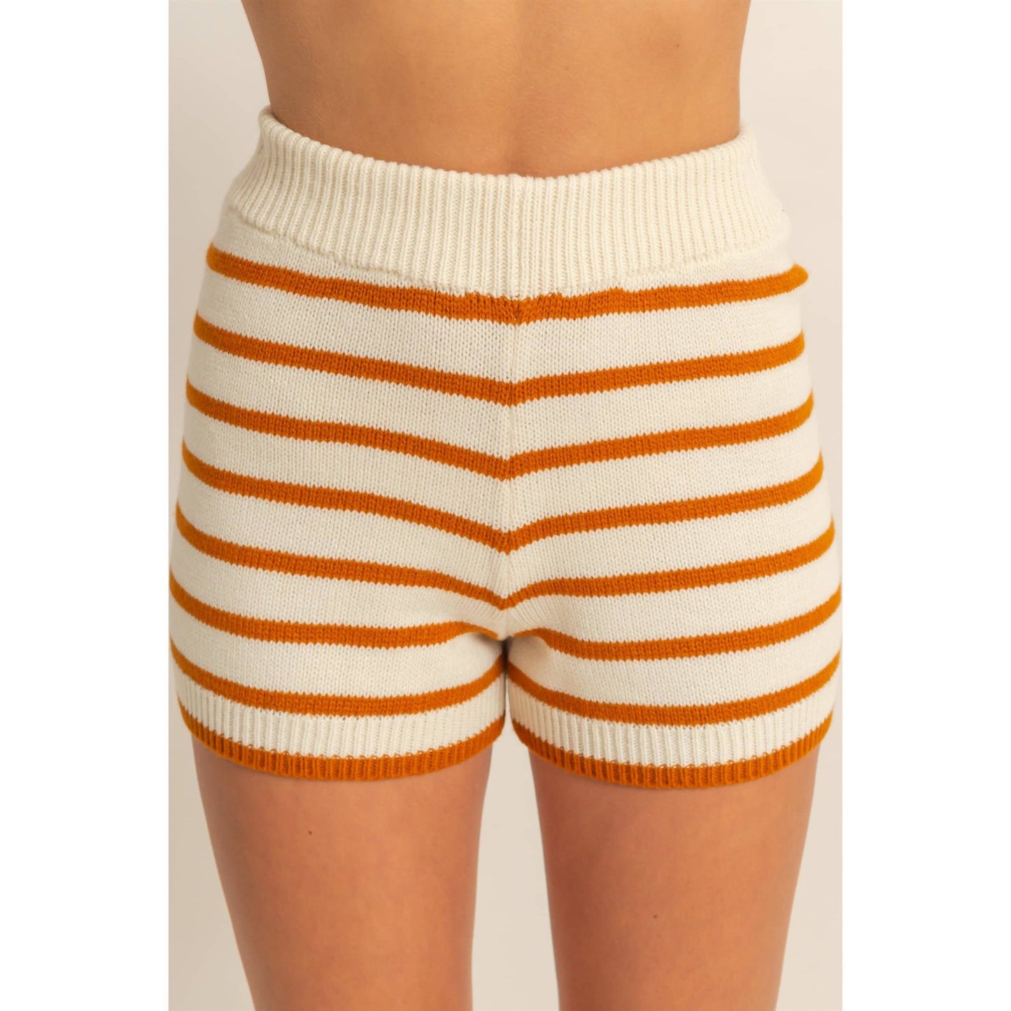 White and orange striped shorts on a plain background