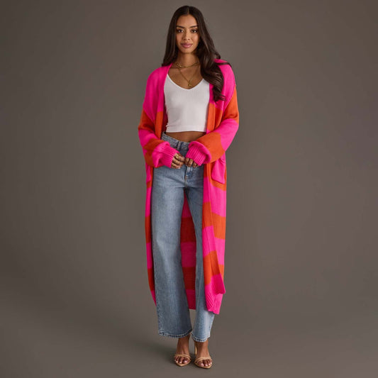 Woman wearing a colorful cardigan over a white top and jeans on a gray background