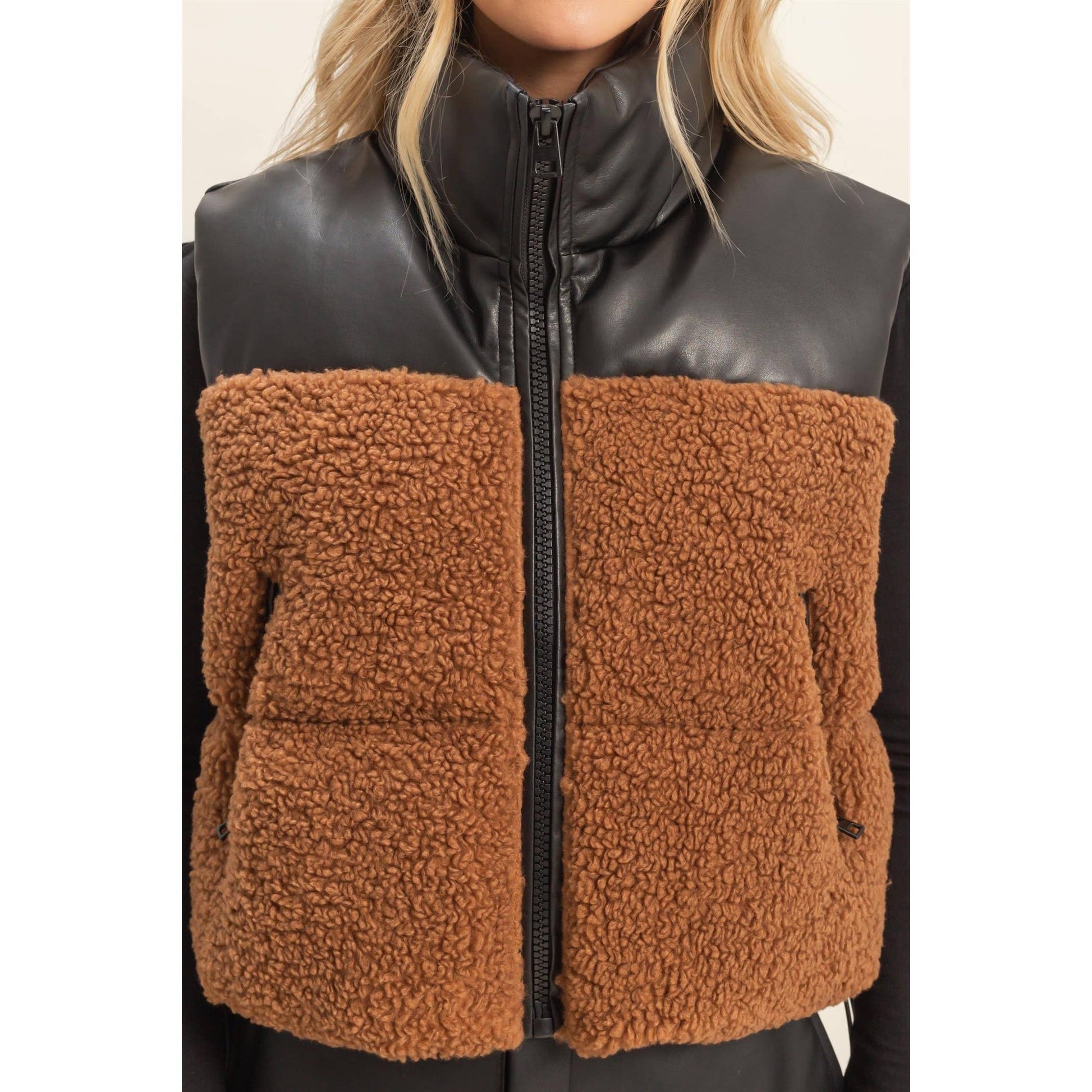 Black leather and brown fleece vest worn by a person