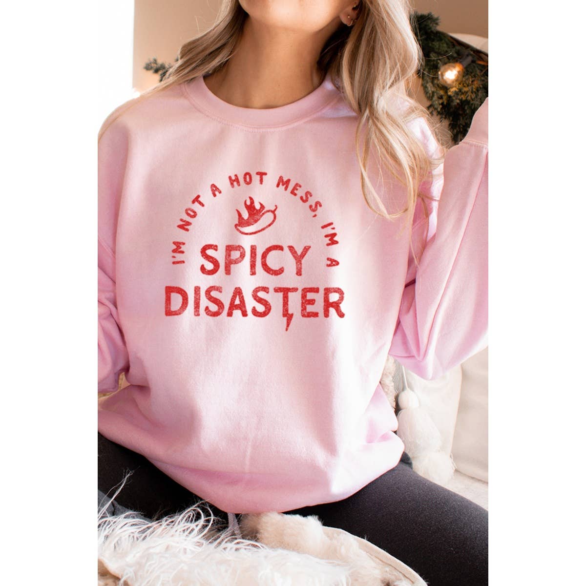 Person wearing a pink sweatshirt with red text in a casual setting