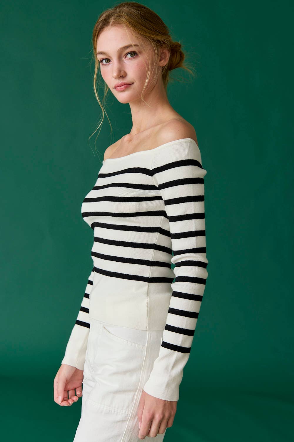Woman wearing a black and white striped sweater against a green background