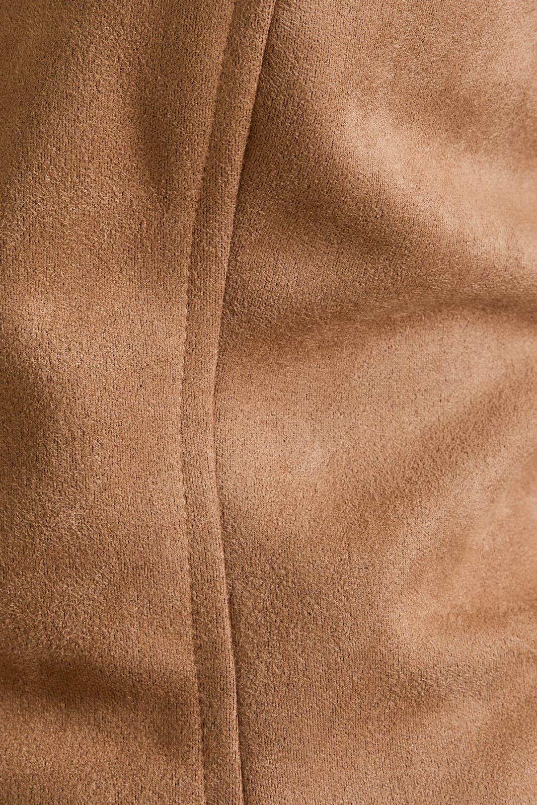 Close-up of brown suede fabric with a visible seam.