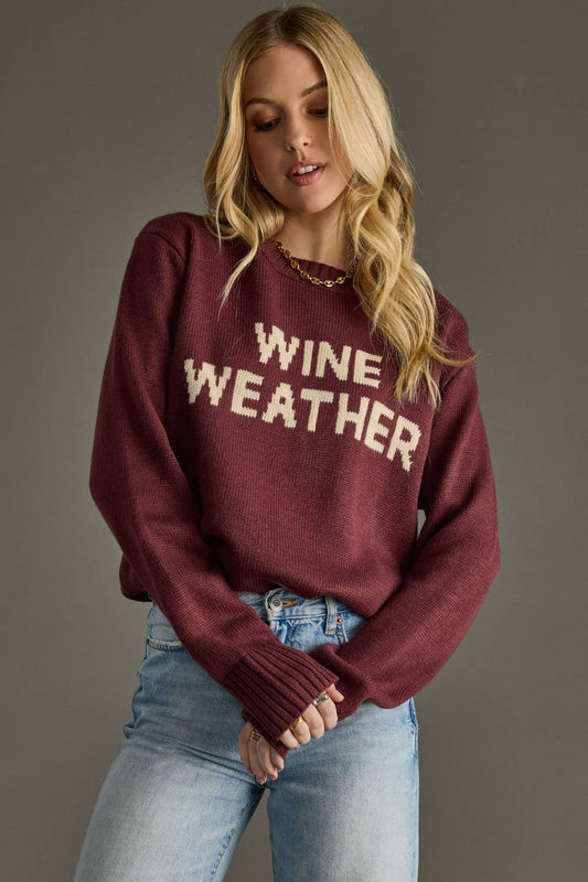 Woman wearing a maroon sweater with 'WINE WEATHER' text against a gray background